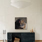 A square canvas art print depicting a dramatic bear and tiger fight, displayed on a textured beige wall above a dark green marble console table in a modern living room setting.