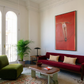 Living room with red sofa, green armchair, and large red painting on white wall. Into Red – Bold Abstract Canvas Wall Art | Large Luxury Print | Brume Art