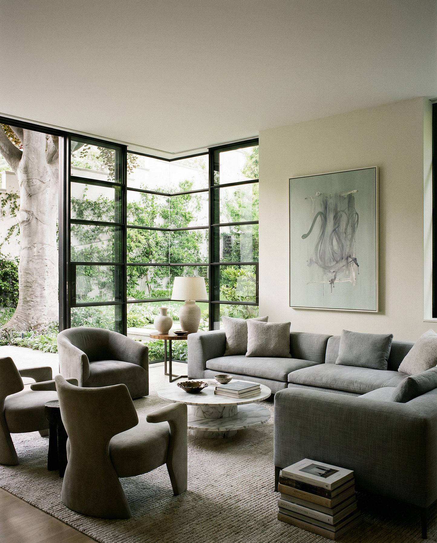 Modern living room with gray sofa, chairs, and a large window view. tension 3 – Textured Abstract Canvas Art | Premium Luxury Wall Decor | Brume Art