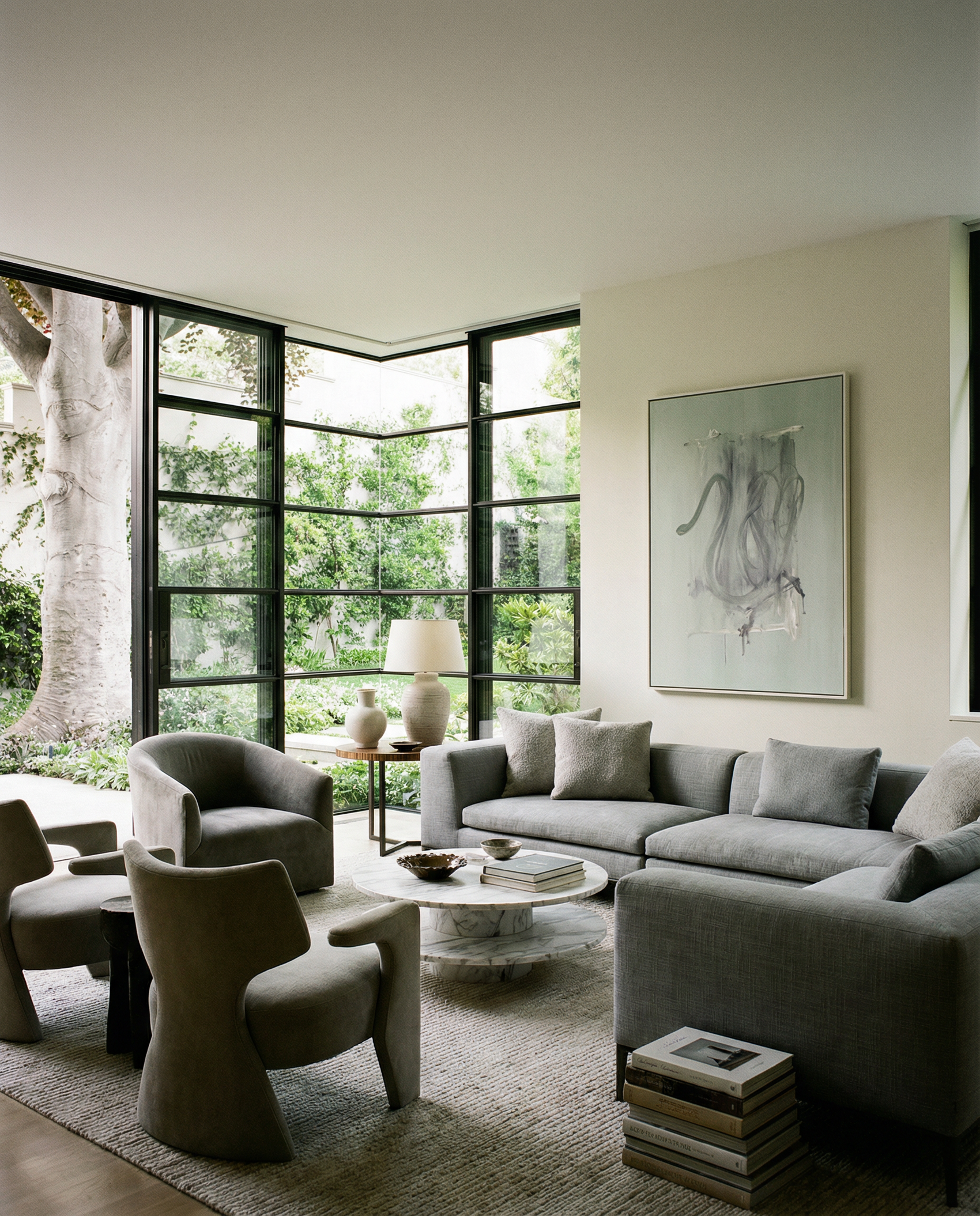 Modern living room with gray sofa, chairs, and a large window view. tension 3 – Textured Abstract Canvas Art | Premium Luxury Wall Decor | Brume Art