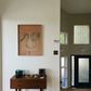 Wooden desk with decorative items against a white wall with a framed artwork. Green Snake 2 – Nature Canvas Wall Art | Premium Luxury Print | Brume Art