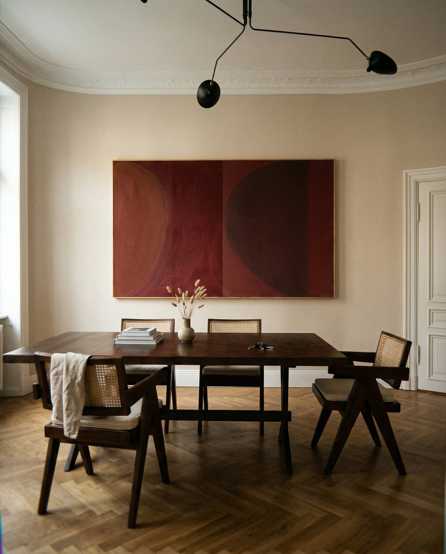 Dining room with a wooden table and chairs, abstract painting on the wall, and a vase with flowers. Eclipse – Contemporary Abstract Canvas | Oversized Luxury Wall Art | Brume Art