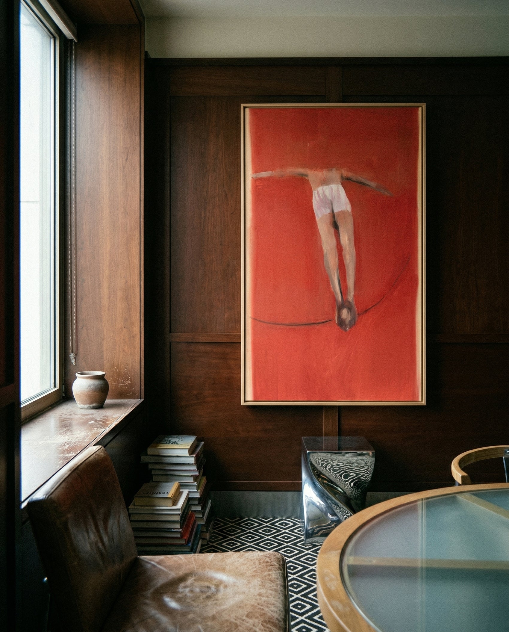 Framed artwork of a dancer on a red background in a room with wooden walls and a window. Into Red – Bold Abstract Canvas Wall Art | Large Luxury Print | Brume Art