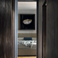 View of a bedroom through a wooden door with a painting on the wall. Pearl – Elegant Abstract Canvas Wall Art | Luxury Giclée Print | Brume Art