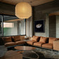 Modern living room with brown sectional sofa, round coffee table, and pendant light. Pearl – Elegant Abstract Canvas Wall Art | Luxury Giclée Print | Brume Art