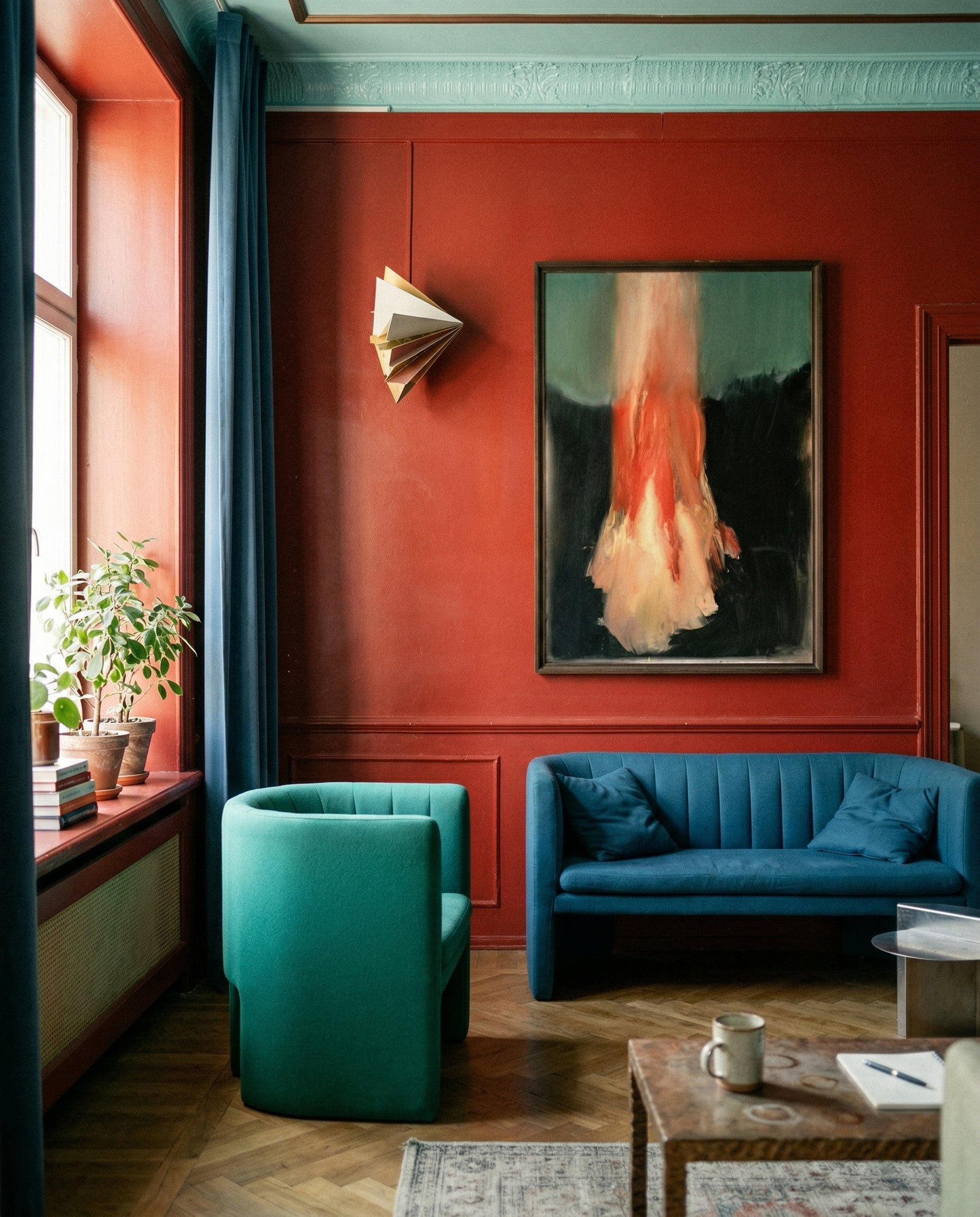 Modern living room with a blue sofa, teal armchair, and red wall. Flame – Expressive Abstract Canvas Art | Large Luxury Wall Print | Brume Art