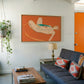 Modern living room with a blue sofa, wooden coffee table, and abstract painting on the wall. Envelope in Orange – Warm Abstract Canvas Art | Luxury Wall Decor | Brume Art