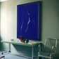 Modern interior with a blue abstract painting on a green wall, a table, and chair.Strike – Bold Abstract Canvas Wall Art | Large Luxury Print | Brume Art