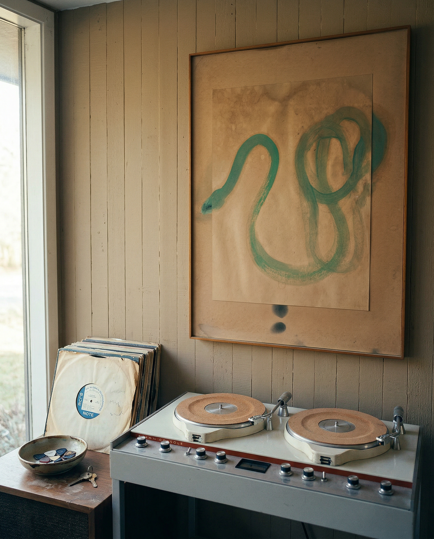 Record player with vinyl records and a painting of a snake on the wall. Green Snake 2 – Nature Canvas Wall Art | Premium Luxury Print | Brume Art