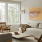 Modern living room with a beige sofa, wooden armchair, and abstract painting. Field Yellow – Landscape Canvas Wall Art | Large Luxury Print | Brume Art