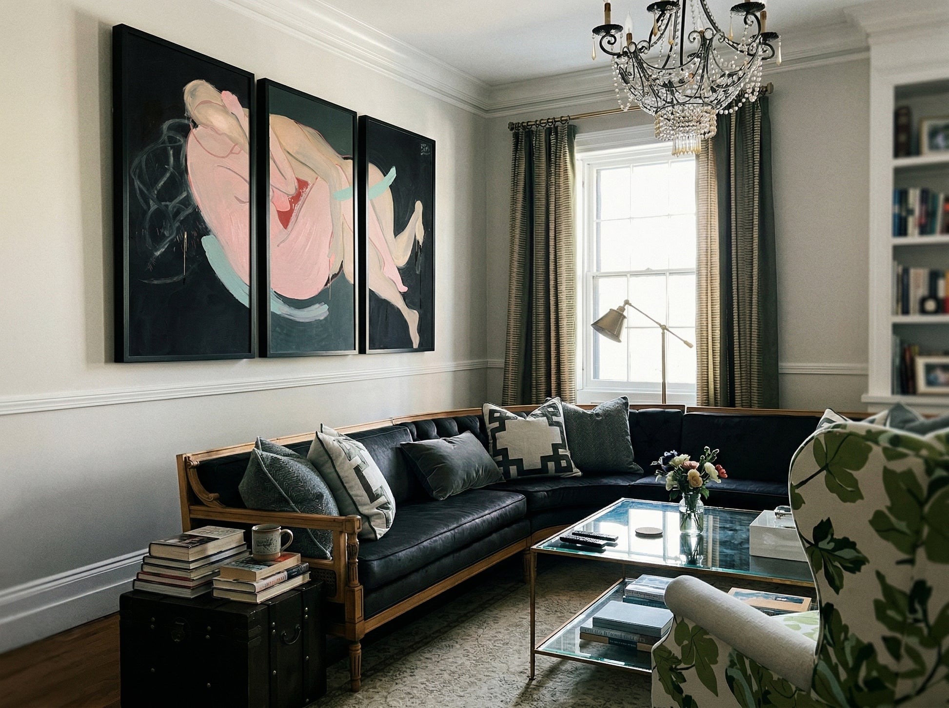 Living room with a black sofa, floral armchair, and wall art. Embrace – Figurative Canvas Wall Art | Oversized Luxury Print | Brume Art