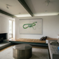 Modern living room with a fireplace, artwork on the wall, and a sofa. Green Snake – Nature Canvas Wall Art | Large Luxury Print | Brume Art