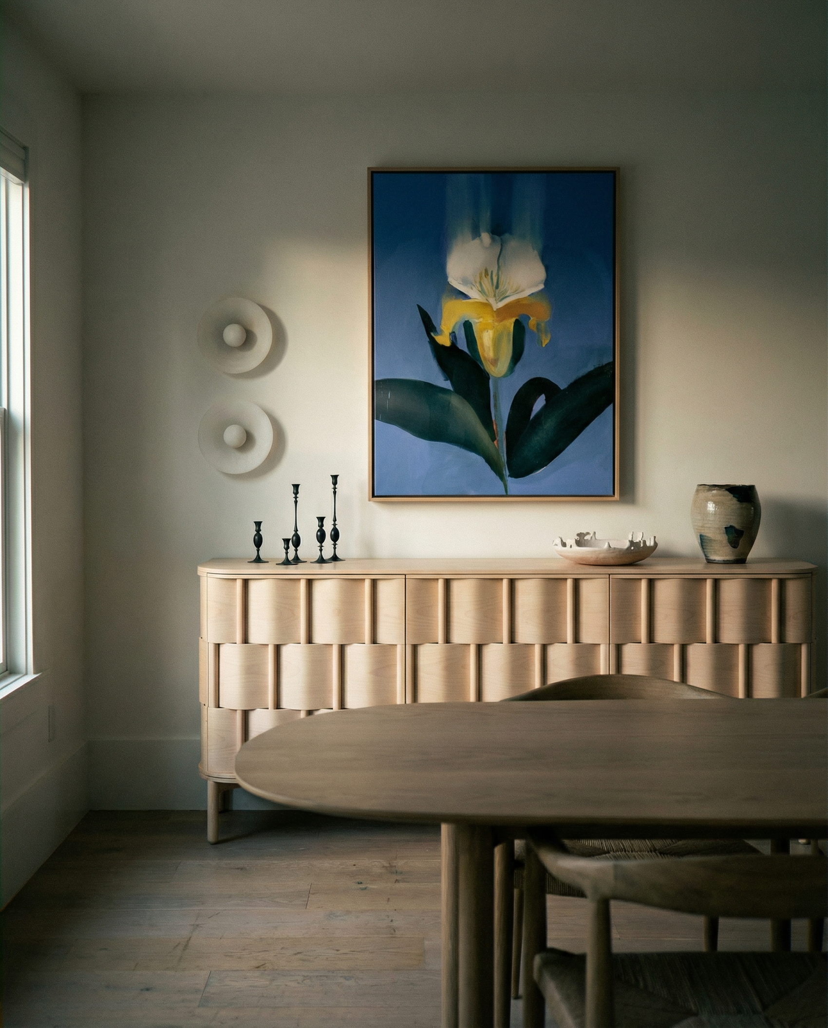 Dining room with wooden sideboard, round table, and floral artwork on the wall. Iris – Botanical Canvas Wall Art | Premium Luxury Print | Brume Art