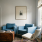 Living room with blue armchairs and a white chair, wooden coffee table, and framed picture on the wall. Seaside retreat Contemporary Sketch Canvas Art | Luxury Wall Decor | Brume Art|