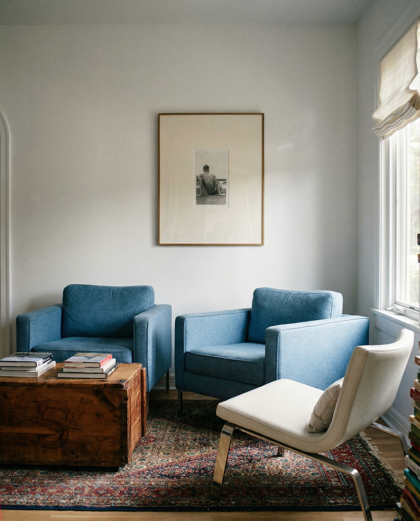 Living room with blue armchairs and a white chair, wooden coffee table, and framed picture on the wall. Seaside retreat Contemporary Sketch Canvas Art | Luxury Wall Decor | Brume Art|