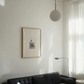 Living room with a black sofa, framed picture on the wall, and a pendant light. Seaside retreat Contemporary Sketch Canvas Art | Luxury Wall Decor | Brume Art|