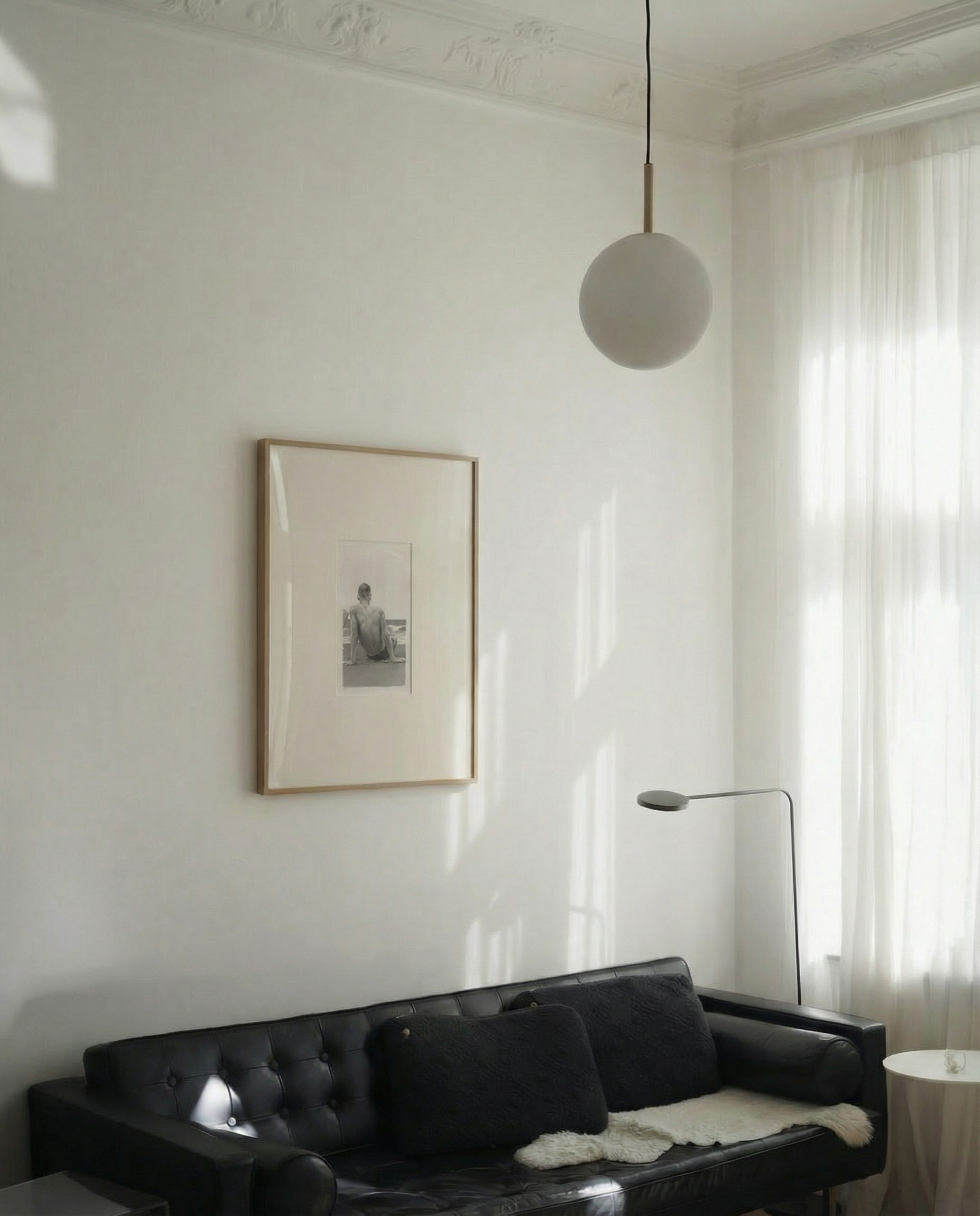 Living room with a black sofa, framed picture on the wall, and a pendant light. Seaside retreat Contemporary Sketch Canvas Art | Luxury Wall Decor | Brume Art|