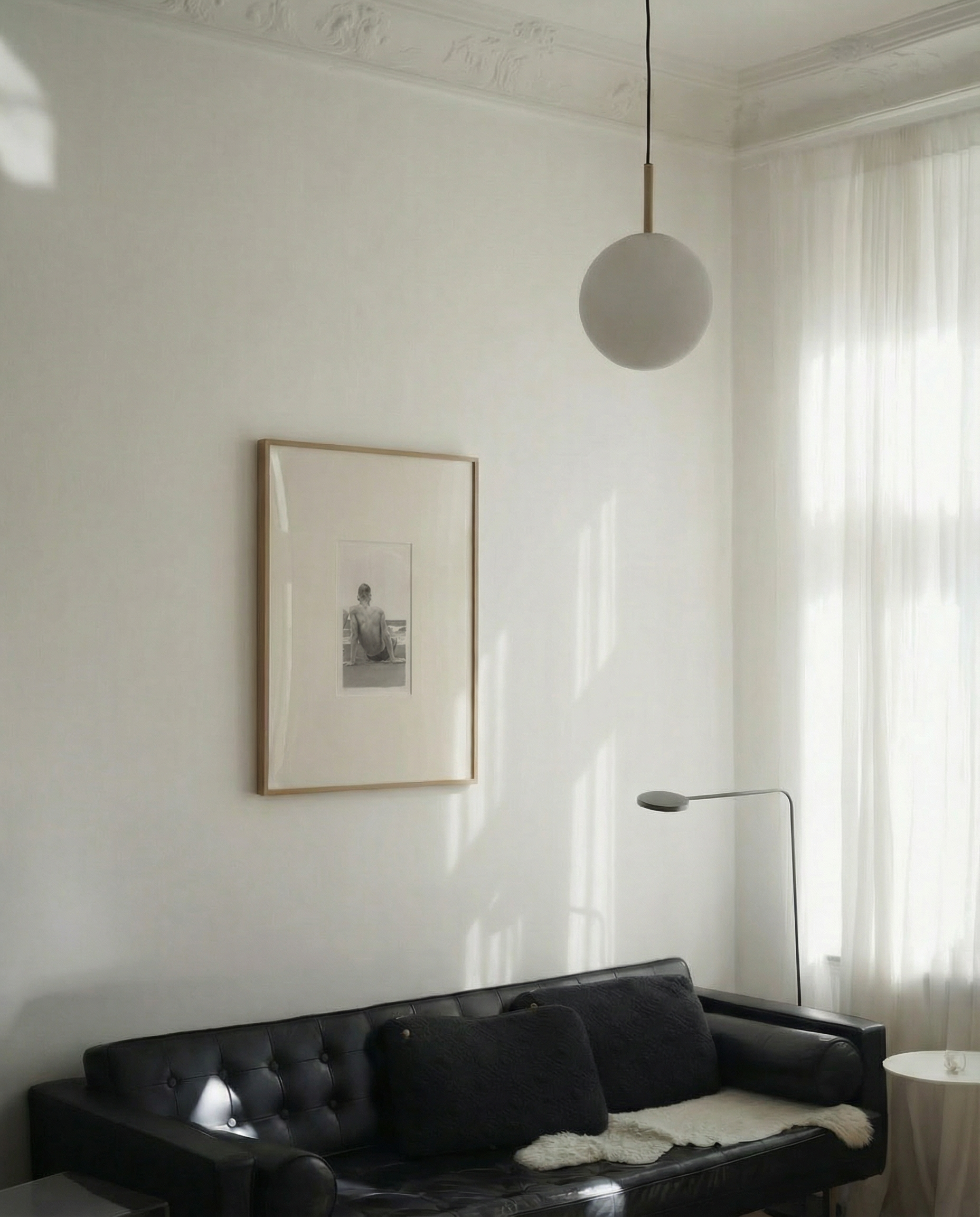 Living room with a black sofa, framed picture on the wall, and a pendant light. Seaside retreat Contemporary Sketch Canvas Art | Luxury Wall Decor | Brume Art|