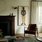Living room with a fireplace, brown leather chair, and framed artwork on the wall. Fisherman of manila-Figurative Canvas Wall Art | Premium Luxury Print | Brume Art