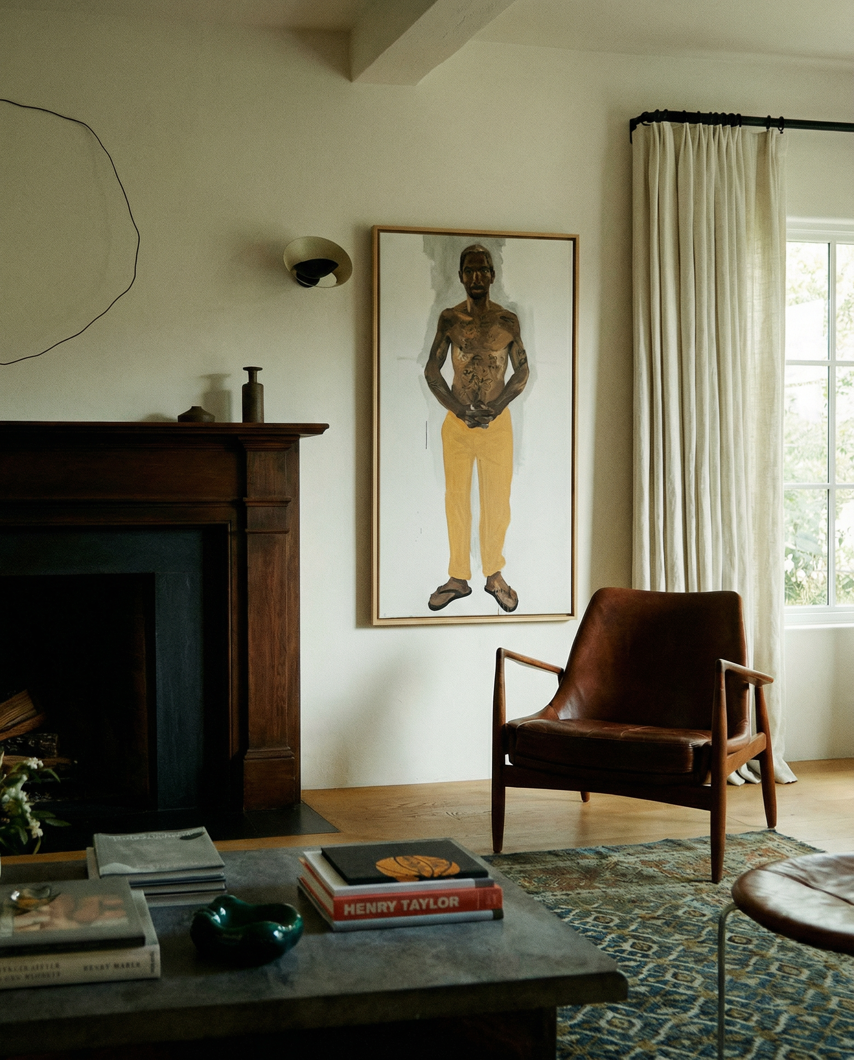 Living room with a fireplace, brown leather chair, and framed artwork on the wall. Fisherman of manila-Figurative Canvas Wall Art | Premium Luxury Print | Brume Art
