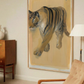 Framed artwork of a tiger on a wall in a room with a chair and lamp. Tiger – Contemporary Animal Canvas Art | Luxury Wall Decor | Brume Art