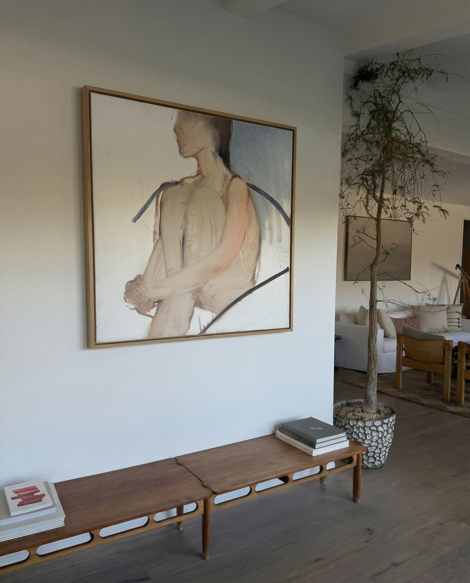 Living room with a large abstract painting on the wall, wooden bench, and indoor plant. Held body – Figurative Canvas Wall Art | Contemporary Luxury Print | Brume Art