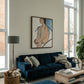Modern living room with a blue sofa, wooden coffee table, and large windows. Held body – Figurative Canvas Wall Art | Contemporary Luxury Print | Brume Art