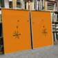 Two orange books with star designs on a bookshelf. Marks – Bold Abstract Canvas Wall Art | Premium Luxury Print | Brume Art