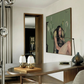 Modern interior with a painting of a woman on a wall, a table with decorative items, and a chair. Bangkok girl– Figurative Canvas Wall Art | Contemporary Luxury Print | Brume Art| Luxury Wall Decor | Large Canvas Wall Art | Oversized Wall Hanging-Brume art