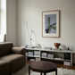 Living room with a brown sofa, hexagonal coffee table, and framed picture on the wall. Orchid – Botanical Canvas Wall Art | Large Luxury Print | Brume Art