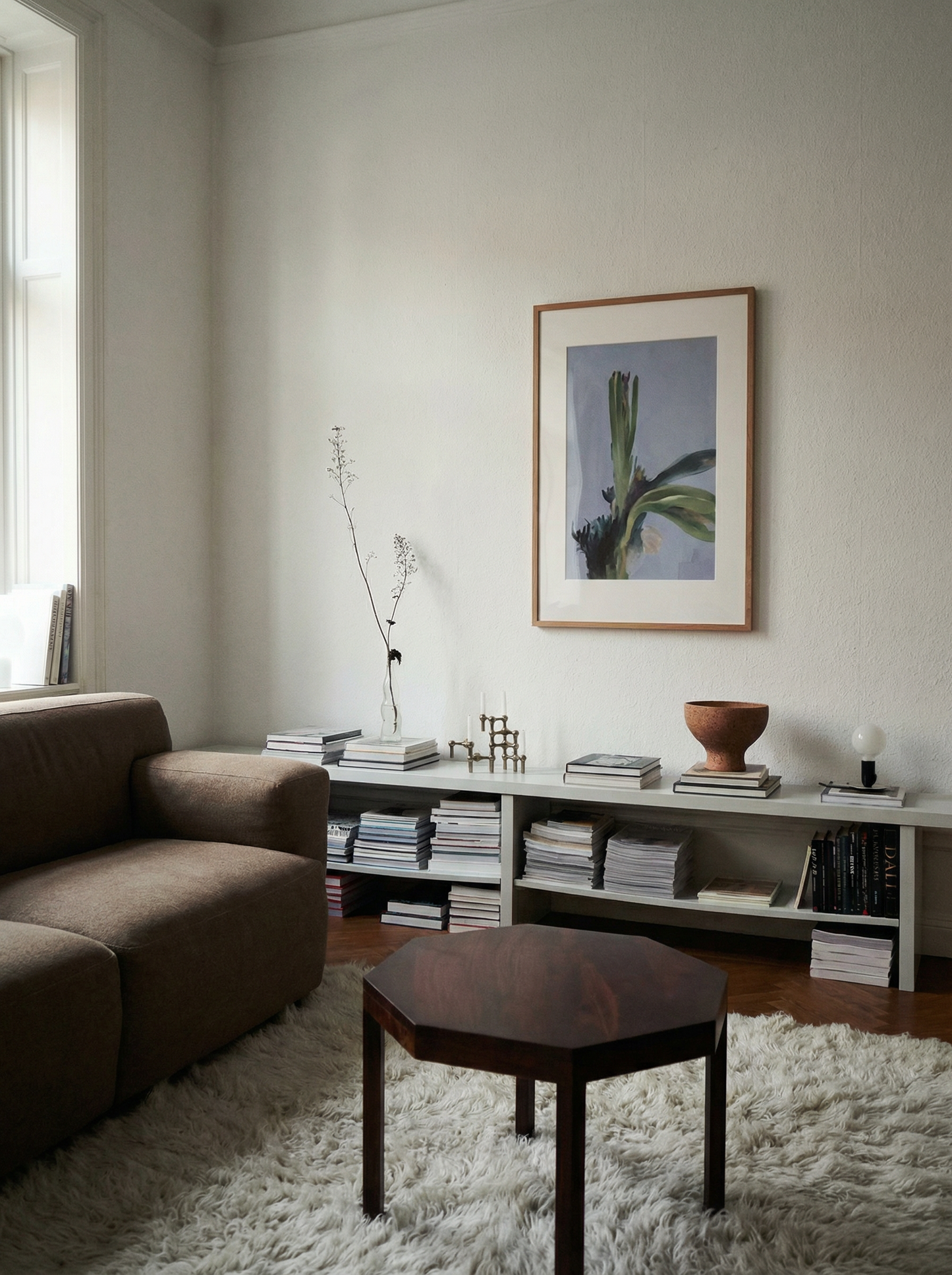 Living room with a brown sofa, hexagonal coffee table, and framed picture on the wall. Orchid – Botanical Canvas Wall Art | Large Luxury Print | Brume Art