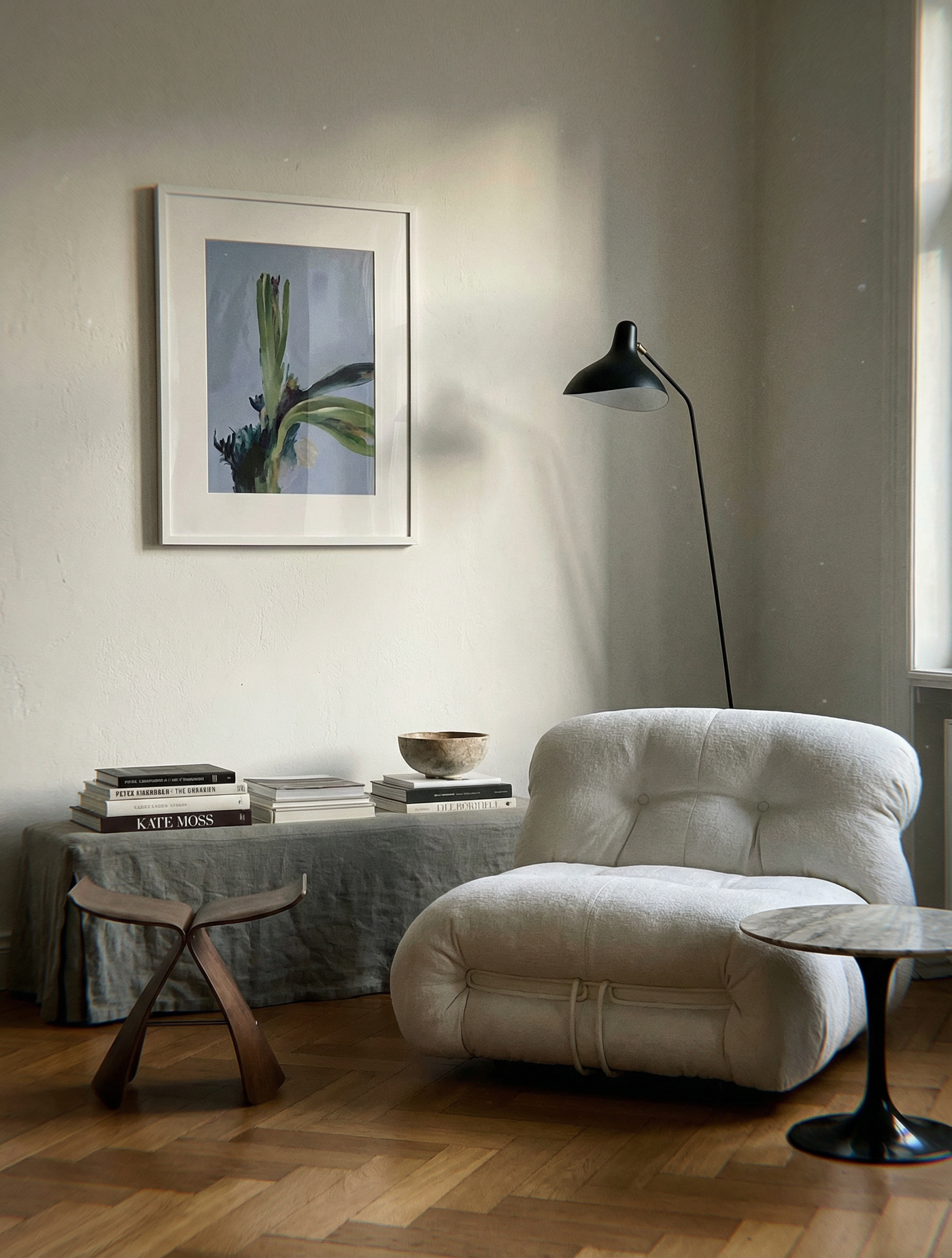 Modern living room with a white armchair, wooden stool, and framed artwork on the wall. Orchid – Botanical Canvas Wall Art | Large Luxury Print | Brume Art
