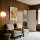 Two beige armchairs in a room with wooden paneling, a lamp, and a door. Golden Bird – Elegant Nature Canvas Print | Luxury Wall Art | Brume Art