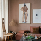 Living room with pink walls, a couch, a coffee table, and framed artwork. Man bathing – Portrait Canvas Wall Art | Large Luxury Print | Brume Art