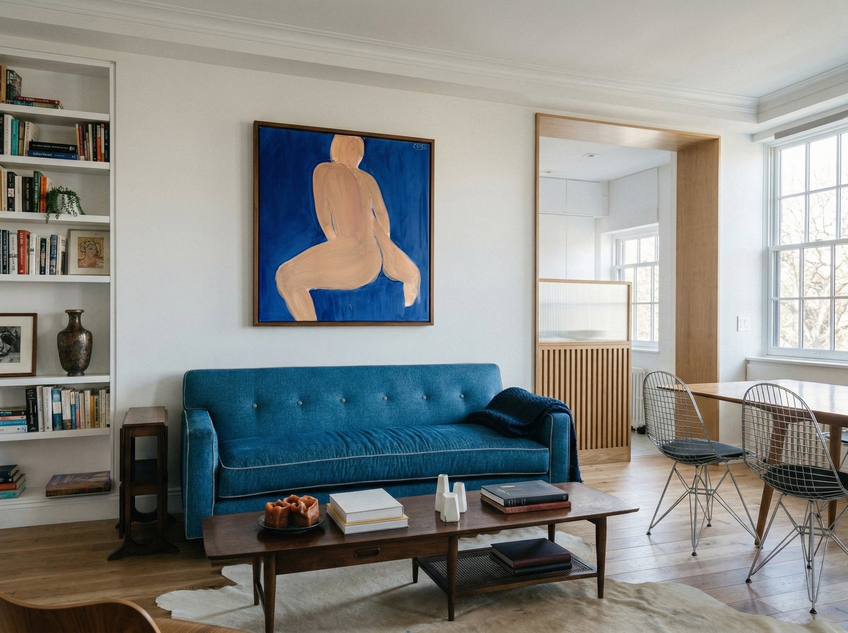 Modern living room with blue sofa, coffee table, and artwork on the wall. Figure in blue – Figurative Abstract Canvas | Premium Wall Art | Brume Art | Luxury Wall Decor | Large Canvas Wall Art | Oversized Wall Hanging-Brume art