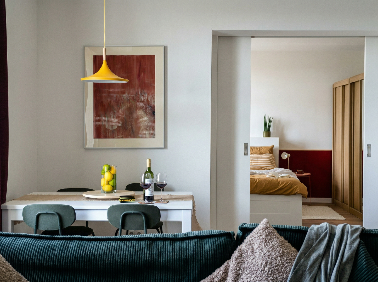 Living room with a dining table and chairs, and a bedroom in the background. Field red – Bold Abstract Canvas Print | Large Luxury Wall Art | Brume Art