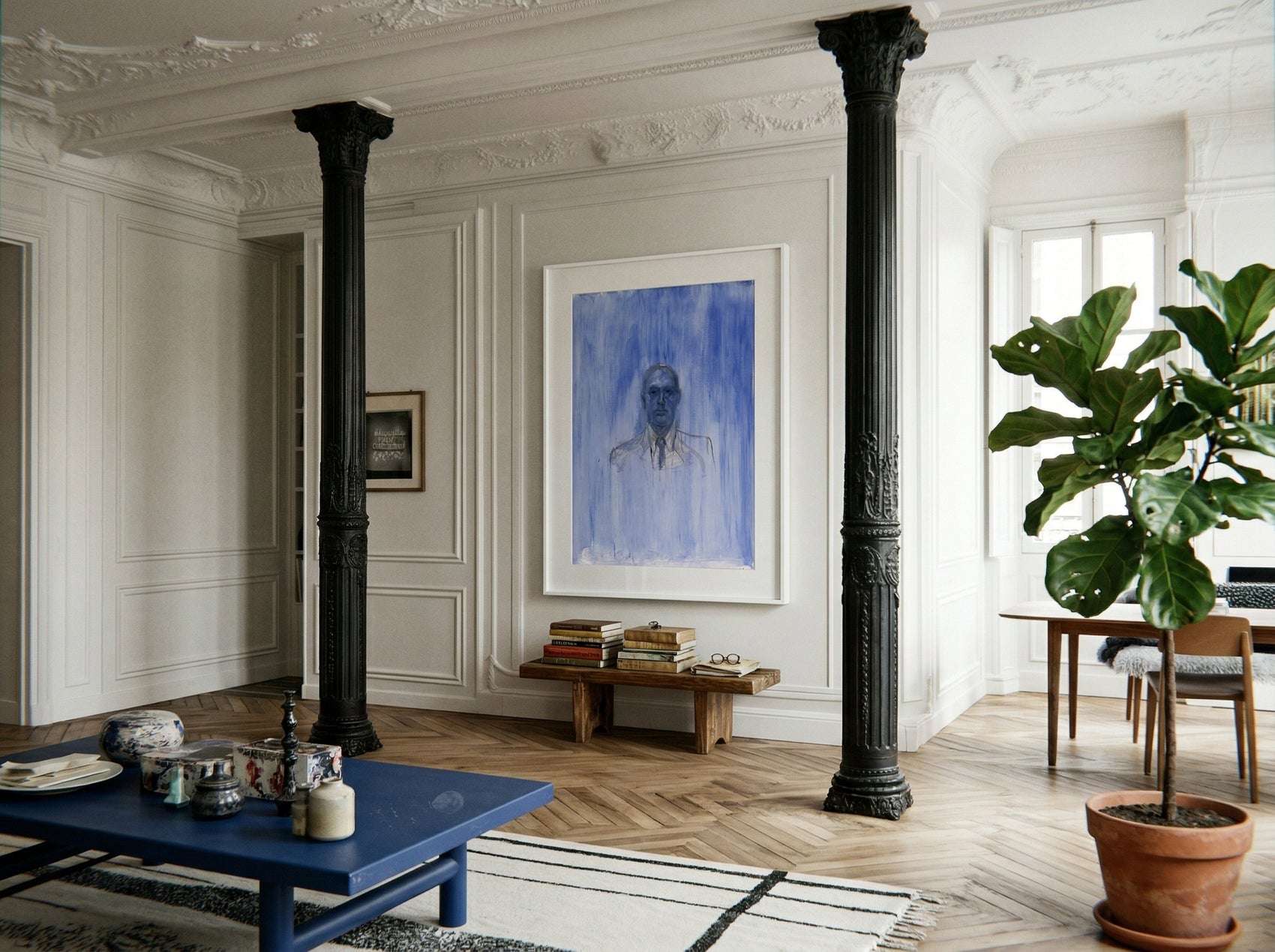 Living room with a blue coffee table, framed portrait, and potted plant. Portrait of a Man – Contemporary Portrait Canvas | Luxury Wall Art | Brume Art | Luxury Wall Decor | Large Canvas Wall Art | Oversized Wall Hanging-Brume art