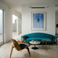 Modern living room with a blue sofa, wooden chair, and abstract painting on the wall. Portrait of a Man – Contemporary Portrait Canvas | Luxury Wall Art | Brume Art | Luxury Wall Decor | Large Canvas Wall Art | Oversized Wall Hanging-Brume art
