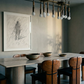 Dining room with a long table and chairs, abstract art on the wall, and a modern chandelier. Silhouette Sketch – Figurative Sketch Canvas Print | Luxury Wall Art | Brume Art
