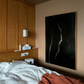 Modern bedroom with wooden headboard, white bedding, and a dark abstract painting. Strike 2 – Bold Abstract Canvas Wall Art | Premium Luxury Print | Brume Art