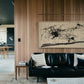 Modern living room with black leather sofa, abstract painting, and wooden wall. Ink – Abstract Ink Canvas Wall Art | Large Premium Print | Brume Art | Luxury Wall Decor | Large Canvas Wall Art | Oversized Wall Hanging-Brume art