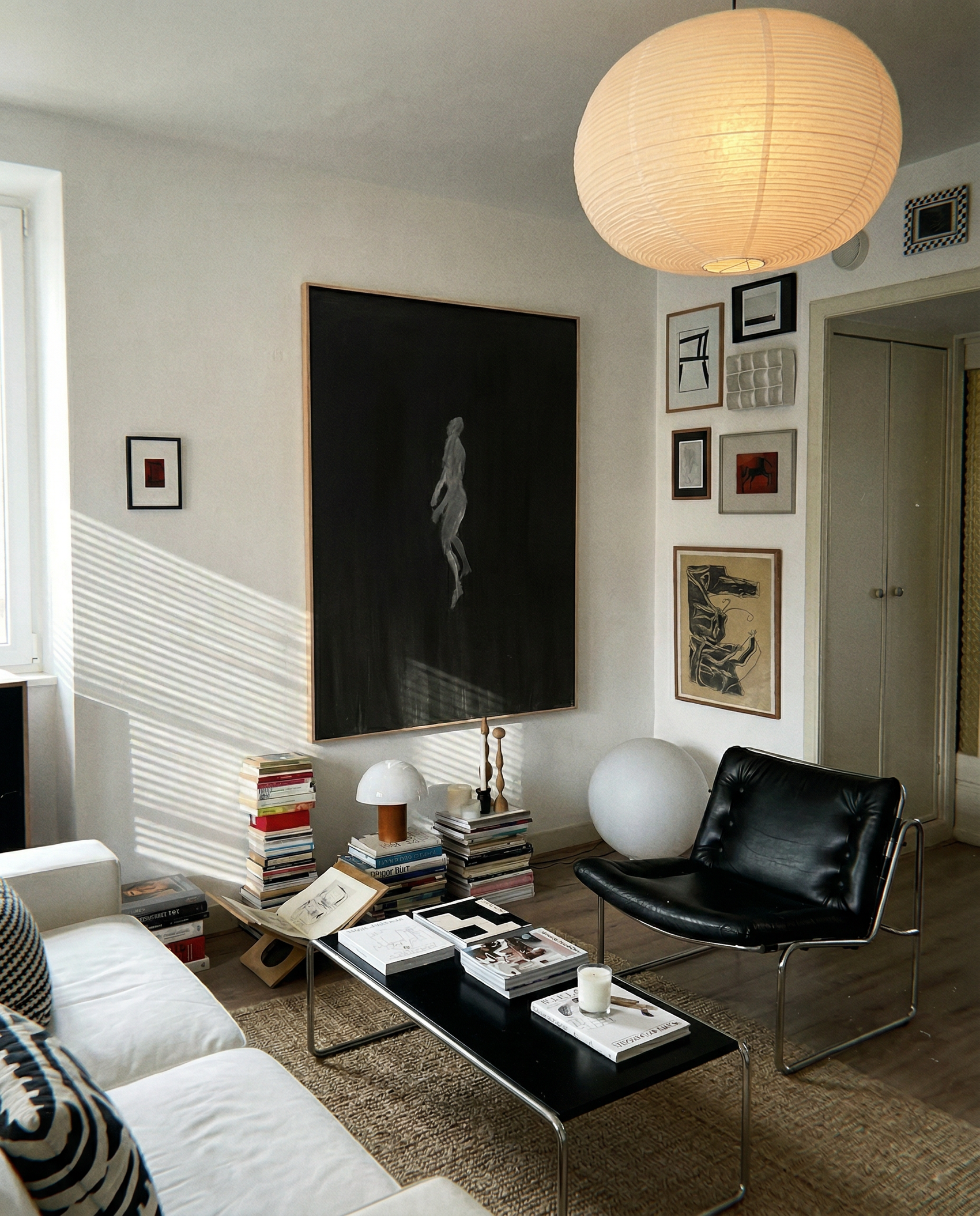 Modern living room with a black leather chair, white sofa, and decorative items. In the black – Bold Abstract Canvas Wall Art | Large Luxury Print | Brume Art