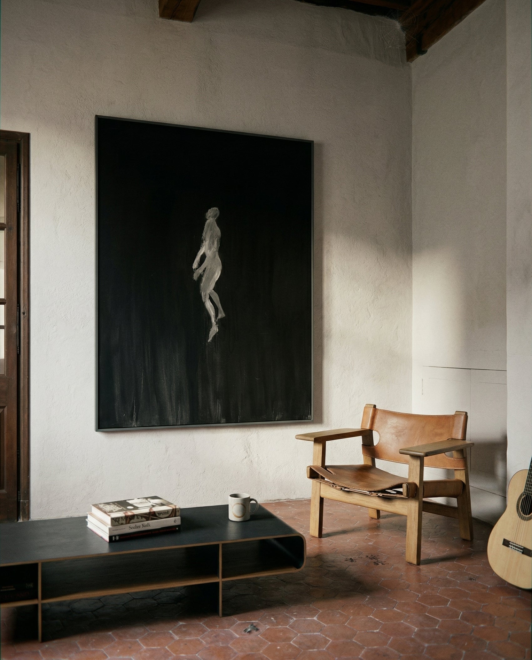 Modern interior with a large black and white painting, leather chair, and guitar on a textured floor. In the black – Bold Abstract Canvas Wall Art | Large Luxury Print | Brume Art