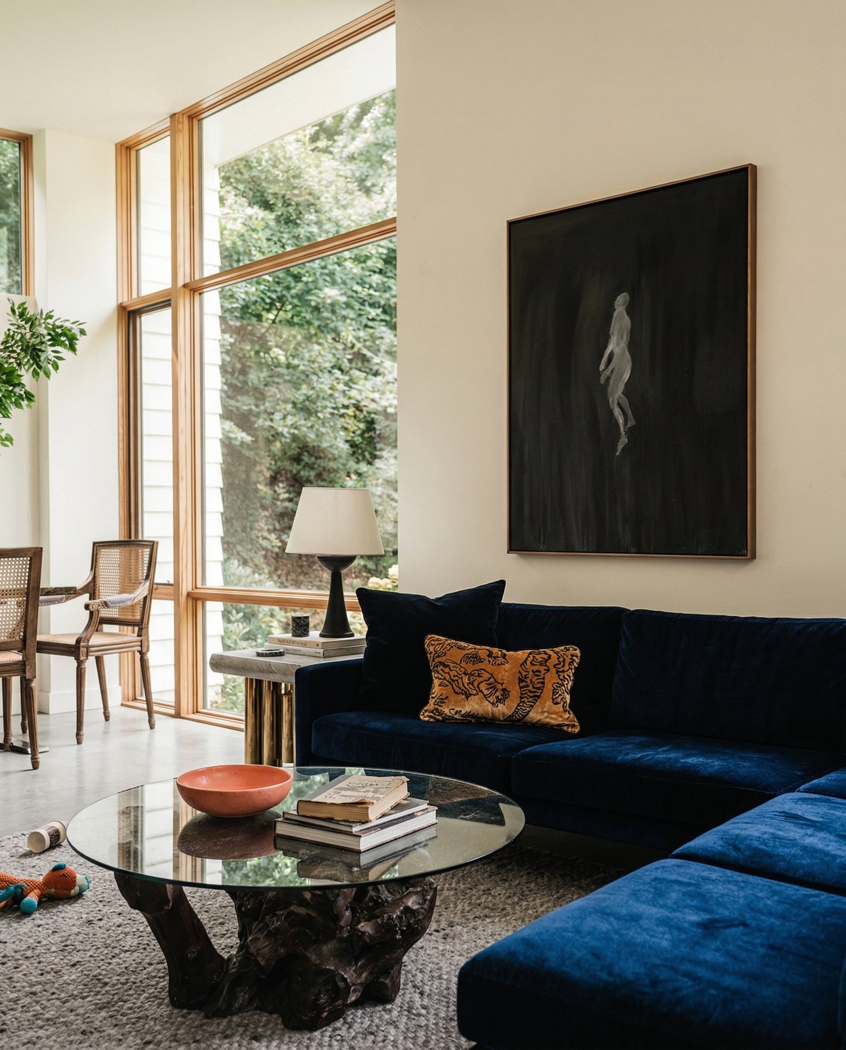 Modern living room with a blue sofa, glass coffee table, and large windows. In the black – Bold Abstract Canvas Wall Art | Large Luxury Print | Brume Art