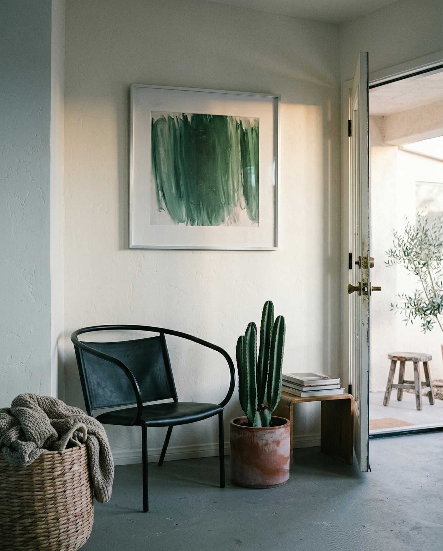 Modern interior with a black chair, potted cactus, and abstract art on a white wall. Field green 3 – Textured Abstract Canvas Art | Premium Luxury Wall Decor | Brume Art