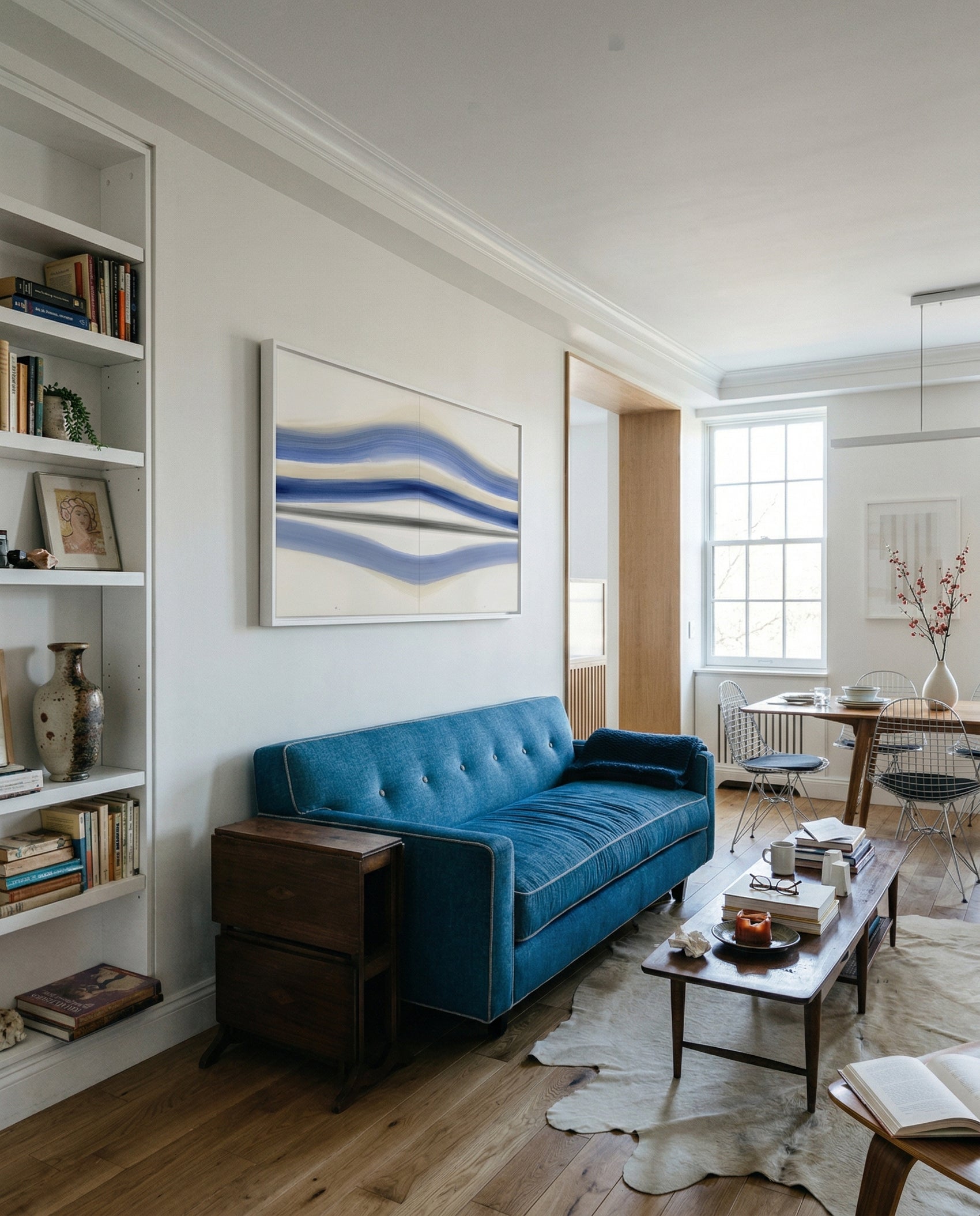 Modern living room with a blue sofa, bookshelf, and abstract painting. Blue Stripes – Abstract Diptych Canvas Art | Large Luxury Wall Print | Brume Art