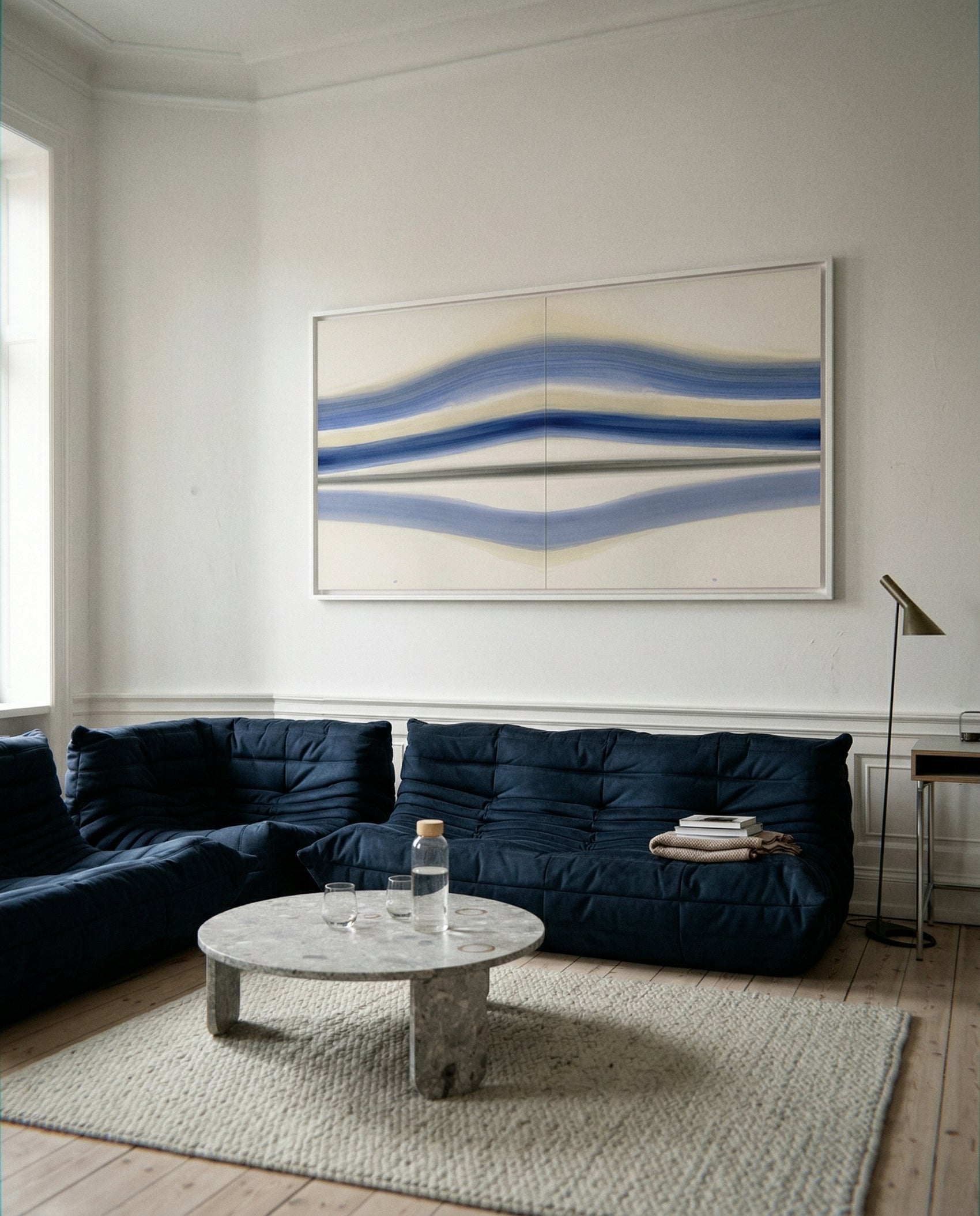 Modern living room with a blue sofa, marble coffee table, and abstract wall art. Blue Stripes – Abstract Diptych Canvas Art | Large Luxury Wall Print | Brume Art