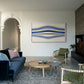 Living room with blue sofa, round wooden coffee table, and abstract art on the wall. Blue Stripes – Abstract Diptych Canvas Art | Large Luxury Wall Print | Brume Art