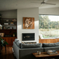 Modern living room with gray sofa, wooden coffee table, and large windows. Noise 4 – Textured Abstract Canvas Art | Premium Luxury Wall Decor | Brume Art | Luxury Wall Decor | Large Canvas Wall Art | Oversized Wall Hanging-Brume art
