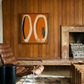 Living room with wooden walls, a leather chair, and abstract art above a fireplace. Form - Bold Abstract Canvas Print | Large Luxury Wall Art | Brume Art | Luxury Wall Decor | Large Canvas Wall Art | Oversized Wall Hanging-Brume art